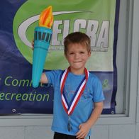 Child with toy torch and medal smiling