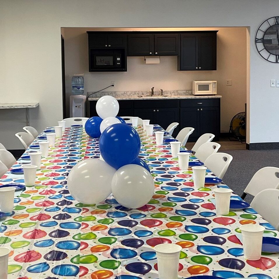 Colorful party table with balloons and cups.